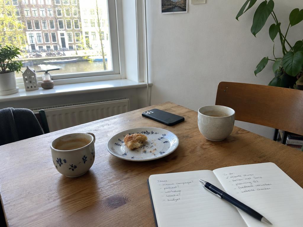 Twee kopjes koffie op een tafel bij het raam
